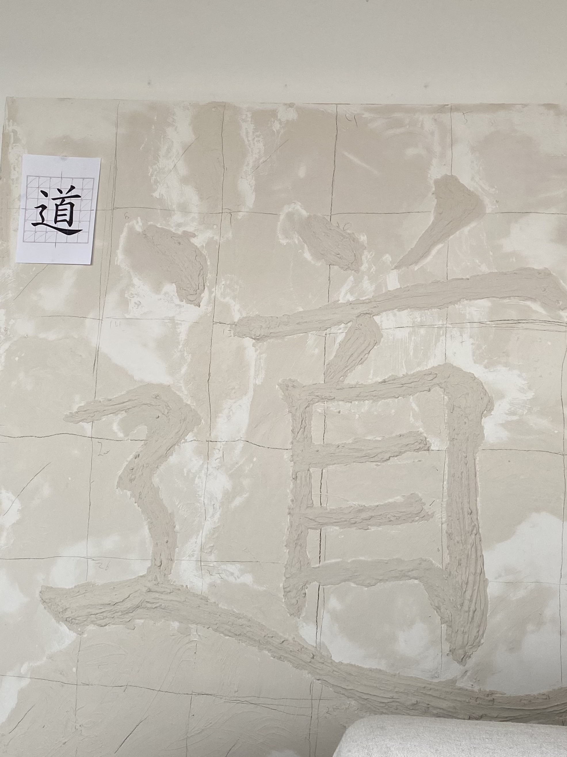 In-progress image of the Dao artwork with character outlines sketched on drywall surface before sculpting.