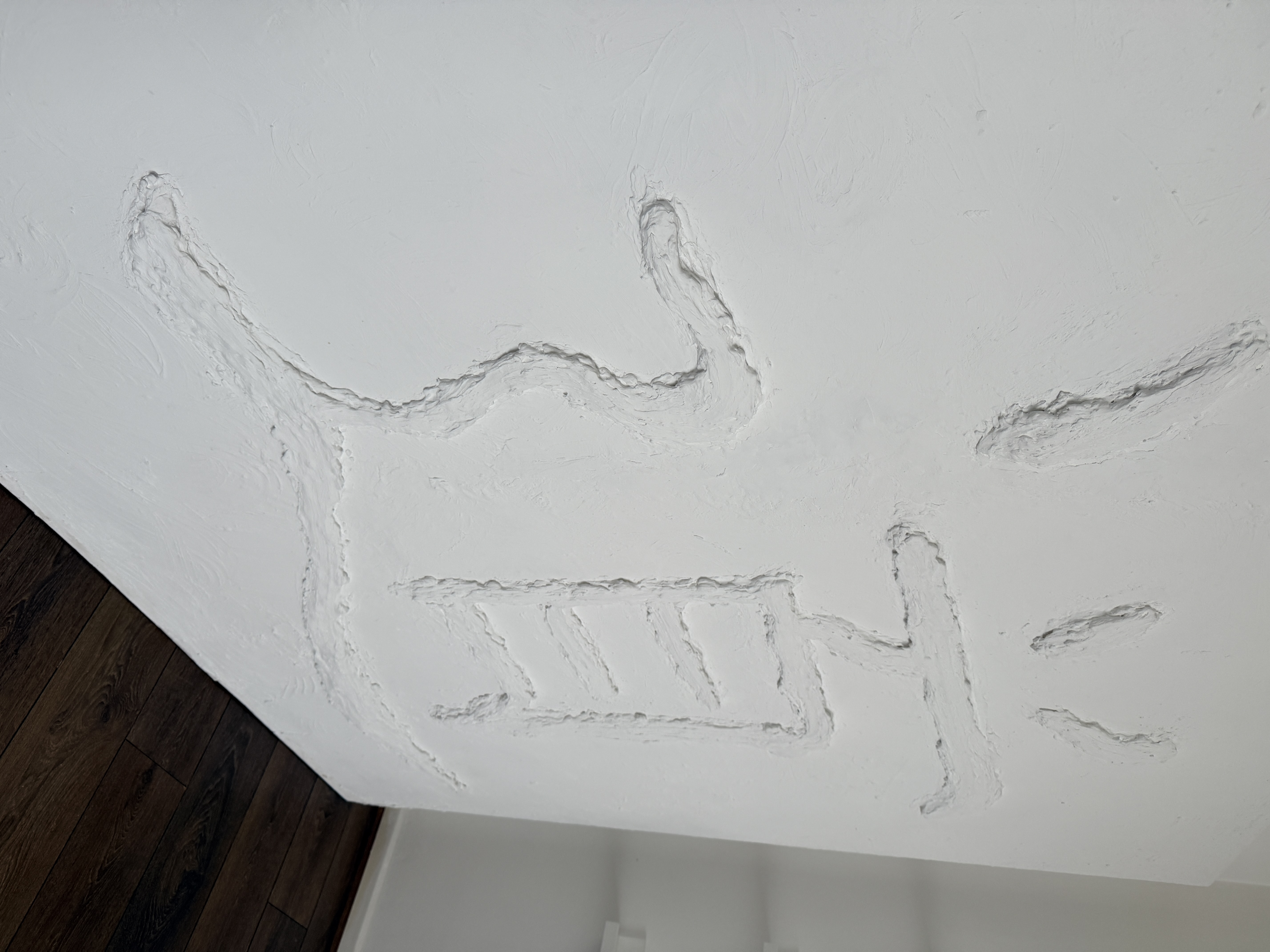 Side view of the Dao artwork showing raised drywall texture and three-dimensional relief design.